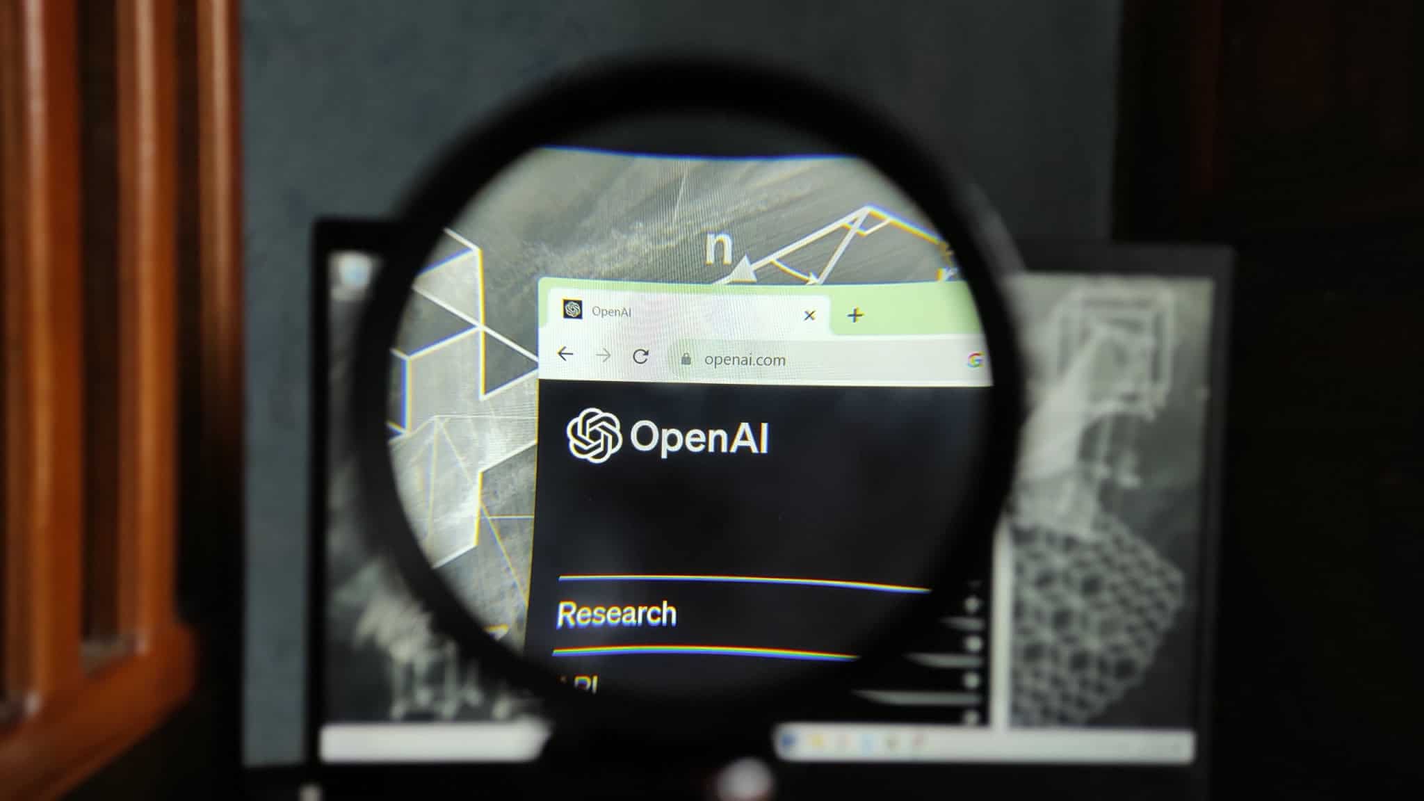 Logo da OpenAI em um navegador de internet observado por meio de uma lupa