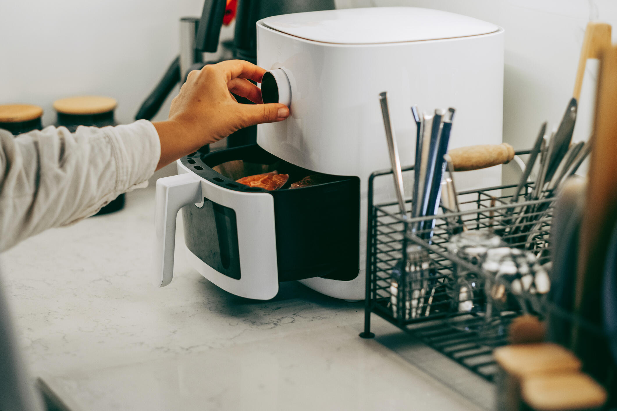 person turning air fryer knob