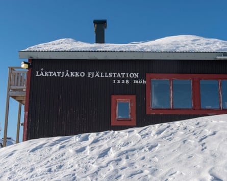A wooden mountain hut with a snow-covered roof