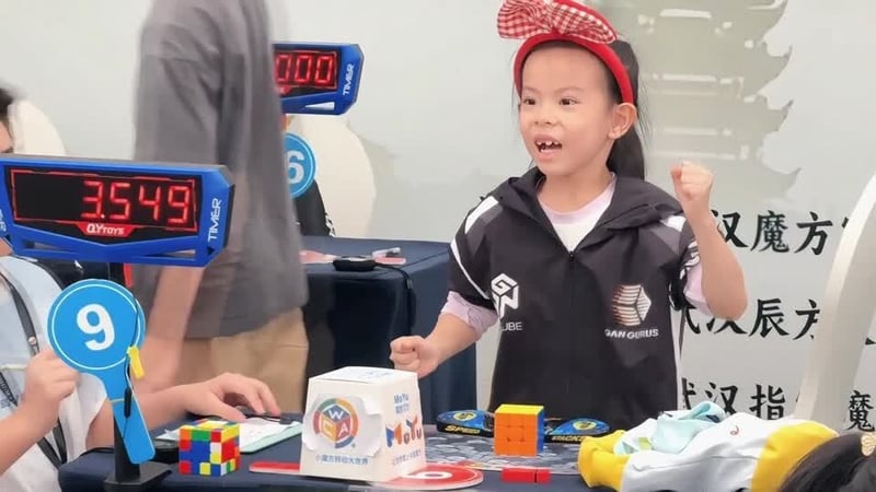 Screen grab shows a small girl celebrating after solving a rubik's cube
