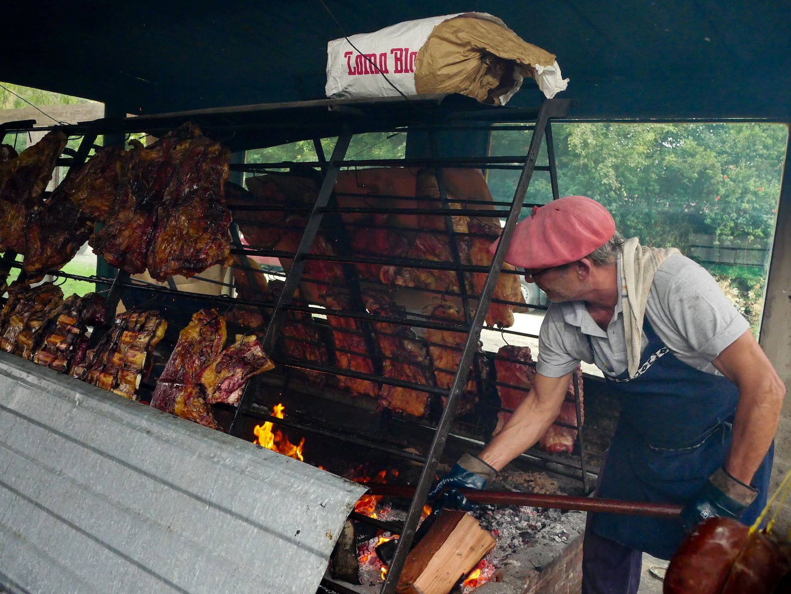 Gaúcho preparando churrasco com carnes, preservando o patrimônio cultural. Renan Braz