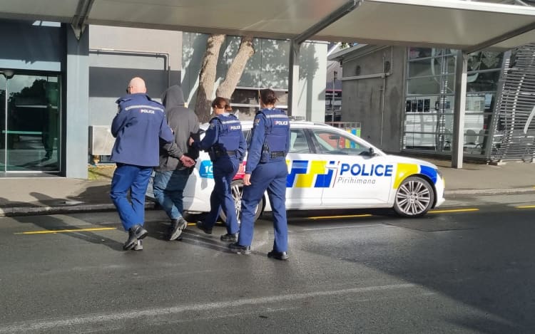 Police officers arrest a man outside New Plymouth's Puke Ariki and bus hub after being reported for waving nunchucks around.