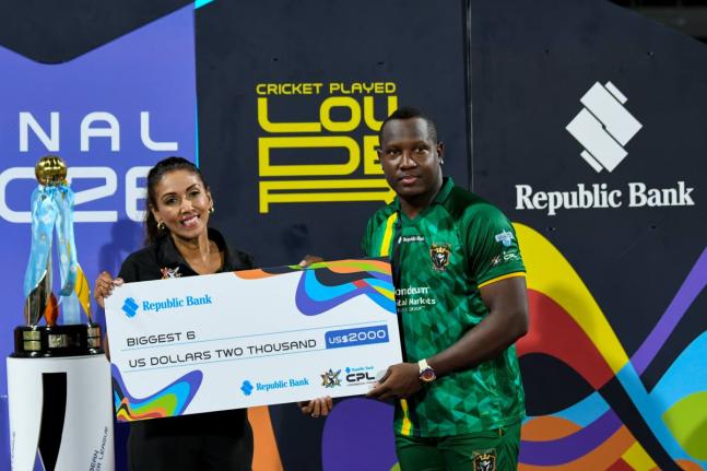 Jamaica Kingsmen Captain Rovman Powell (right) collects a cheque for hitting the biggest six after losing to the Antigua and Barbuda Falcons in this year’s Republic Bank Caribbean Premier League final at Kensington Oval on Sunday.