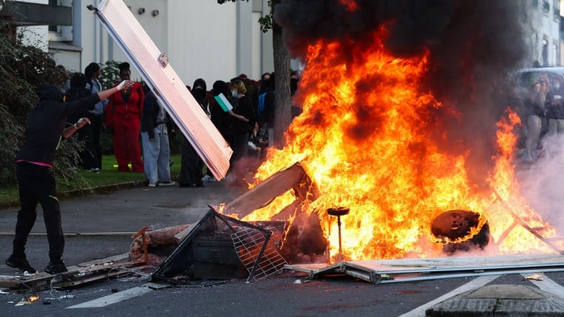 A person throws objects into a fire as protesting students carry out blockading action, in Brest, western France