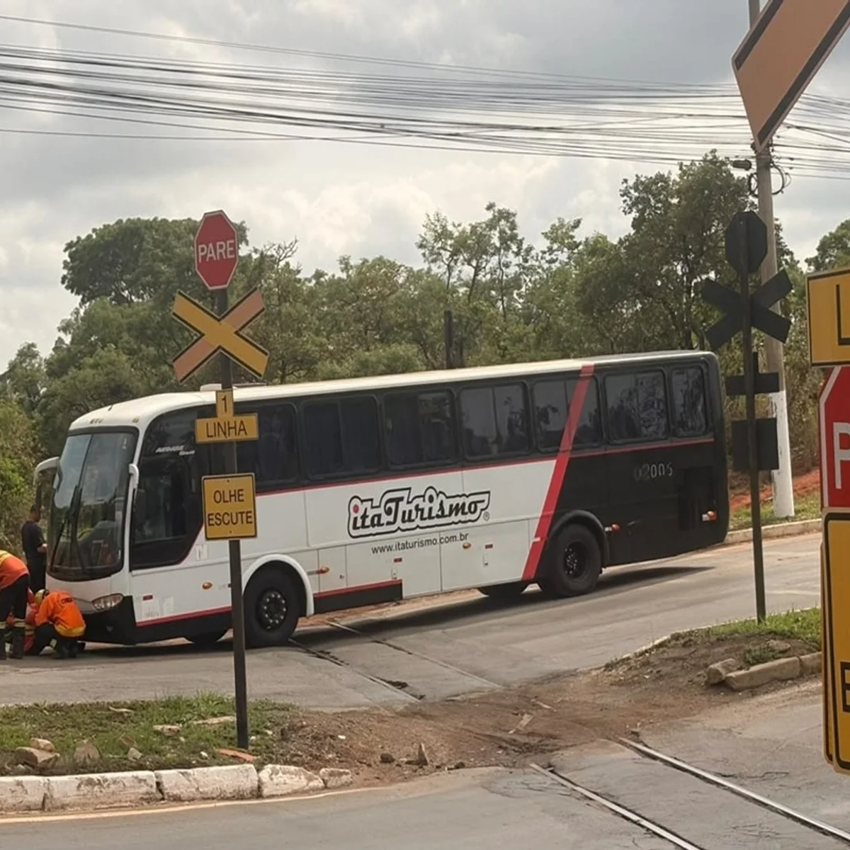 Ônibus fica preso em linha férrea e bombeiros usam guindaste na remoção