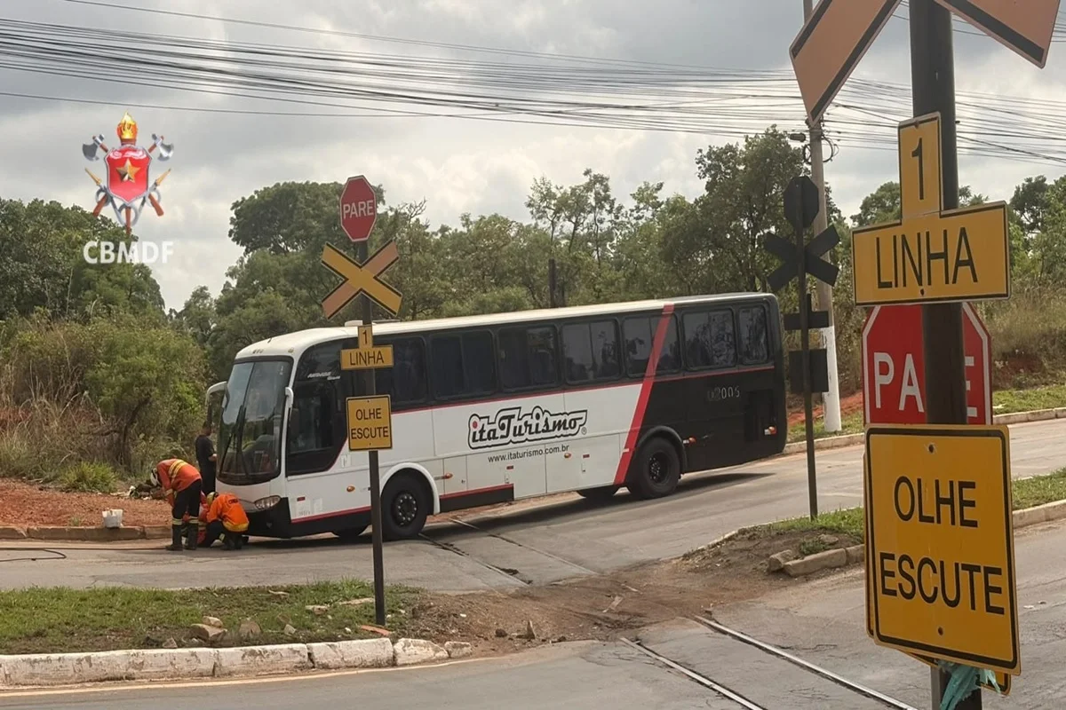 Ônibus fica preso em linha férrea e bombeiros usam guindaste na remoção
